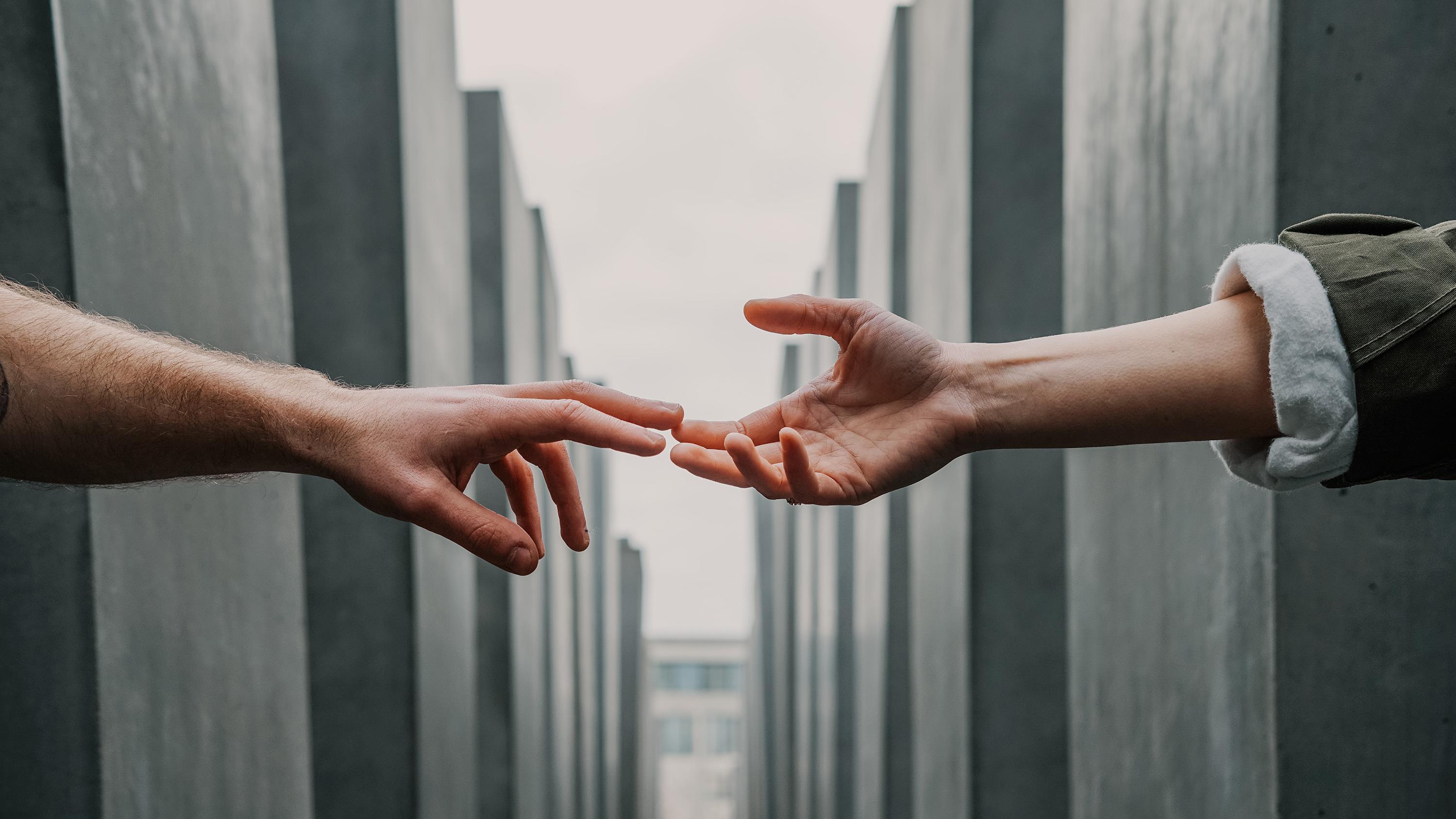 two hands reaching out to one another