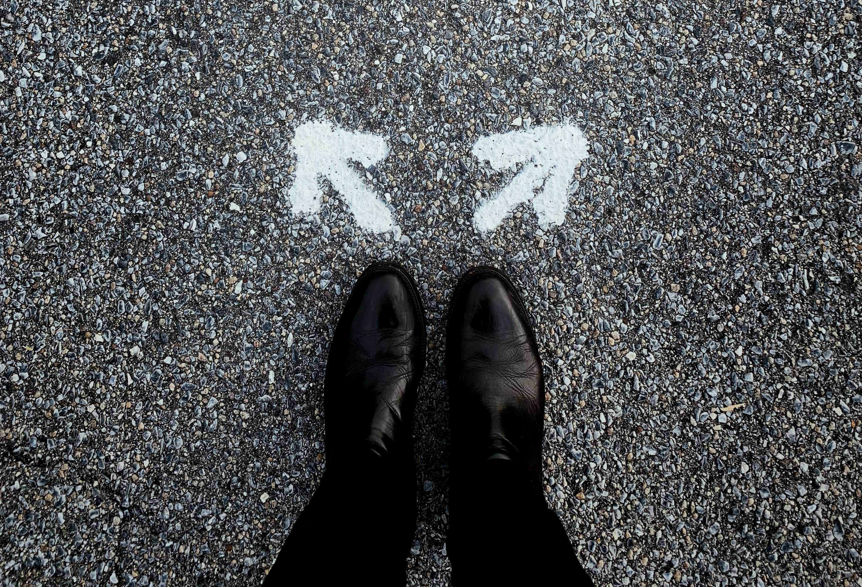 image looking downward a person's feet with two arrows pointing to different directions