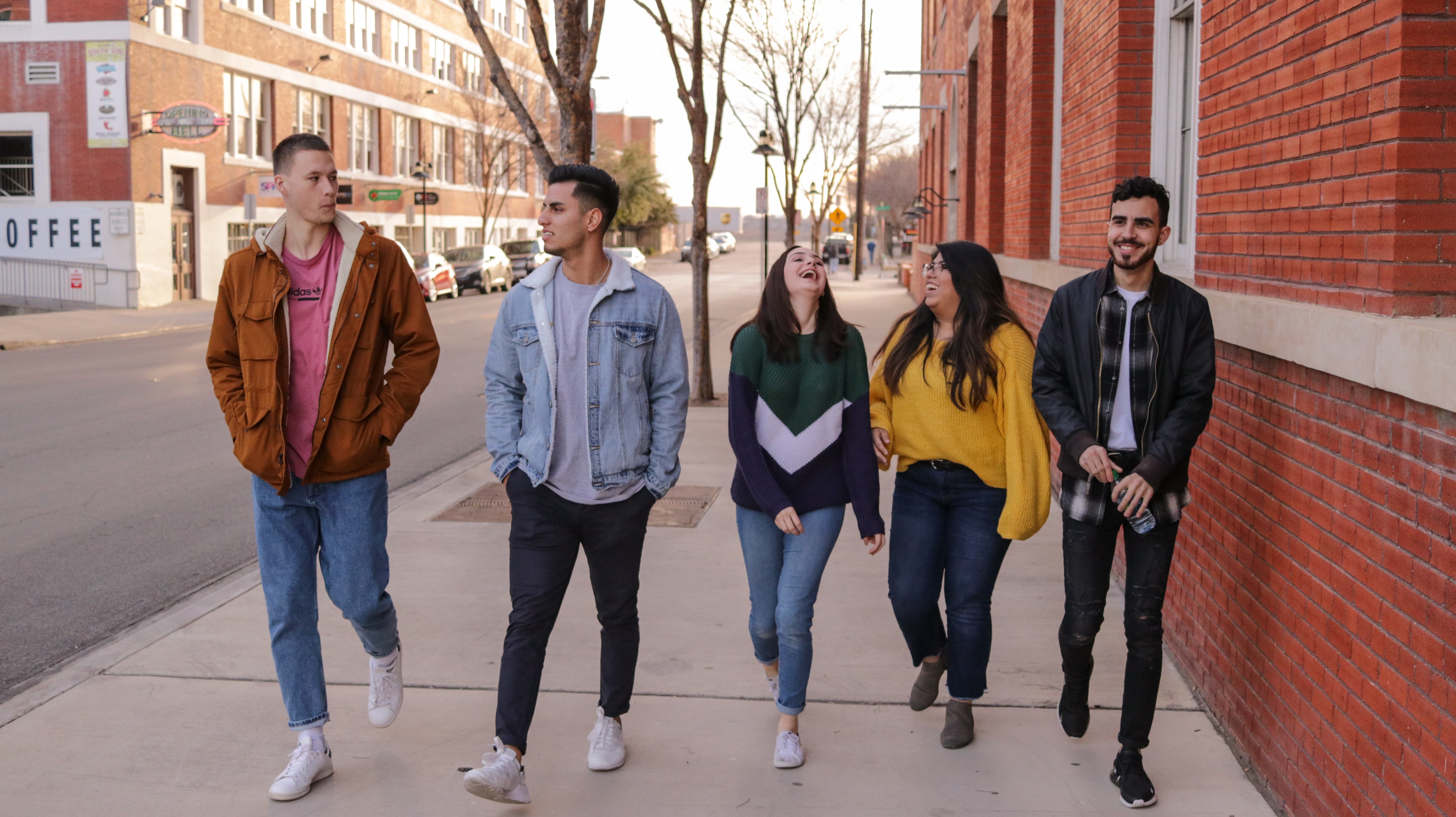 image of 5 college age people walking down the street